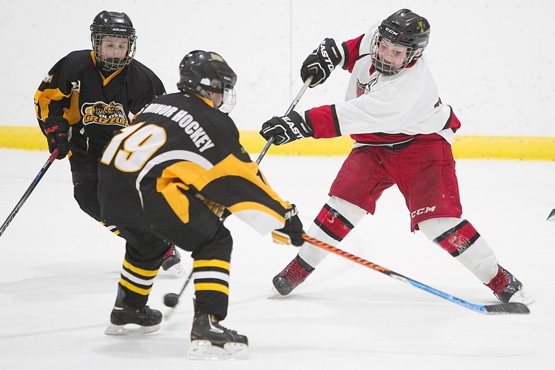 Karter MacKenzie tries to get the puck past an Olds Grizzlys player during the Sundre peewee B Huskies first game of their home tournament, which took place Jan. 5-7 at the