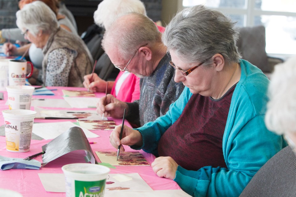 Gilbert Bainton, middle, and Mary Brittian work on their paintings during a drop-in art program at the Sundre Seniors Supportive Living centre on Feb. 20.