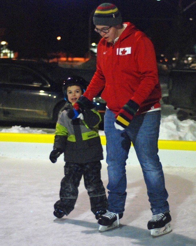 Sundre resident Hayden Korethoski offers his little brother Gavin DeCoste, 6, a helping hand at the outdoor rink &#8211; which is located next to the skatepark by the