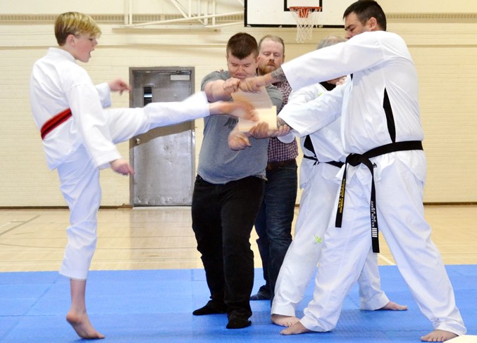 Tristan Hillock kicks through a wooden plank.