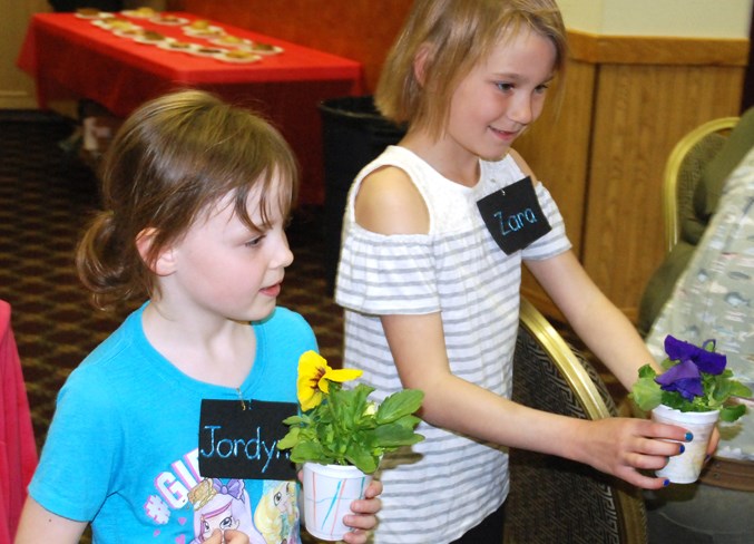  River Valley School Grade 2 students Jordyn Brooks, left, and Zara Bartholow enthusiastically offered some flowers during the event.