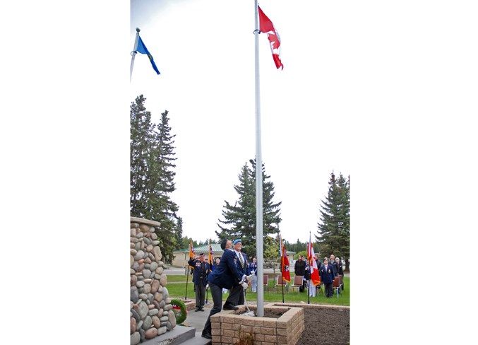  Sergeant-at-arms Jamie Moffatt and comrade Fred Gillies raise the Canadian flag near the end of the ceremony.