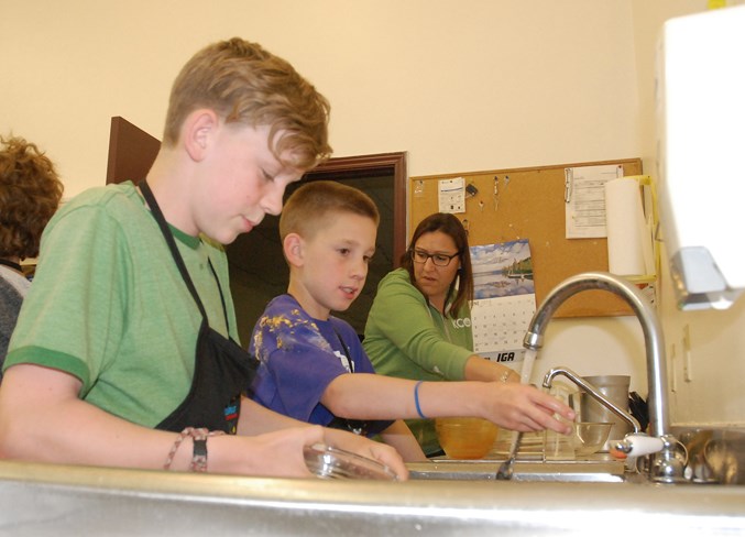  Brothers Hank Hill and Eli Hill wash some dishes, with Greenwood Neighbourhood Place program coordinator Cherie Johnson lending a hand. Simon Ducatel/MVP Staff