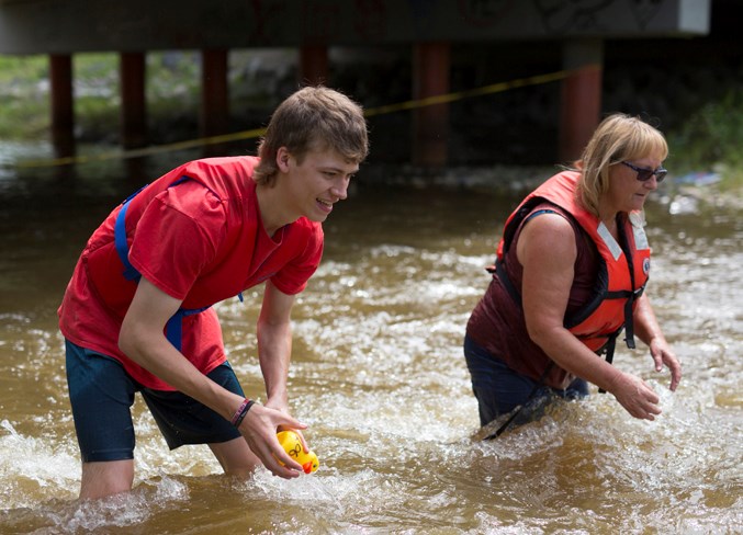  Wyatt McDonald, left, and Carroll Pruner intercept rubber ducks downstream ahead of the Centre Street Bridge. Noel West/MVP Staff