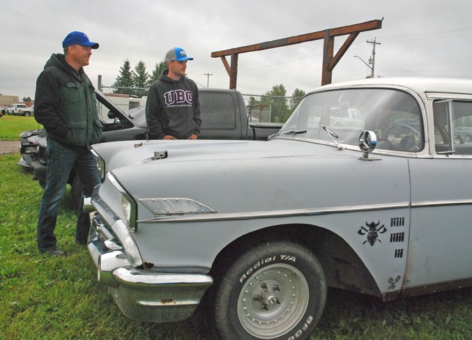  Warren Grimstead, left, and his son Jack, from Bergen, take a look Saturday at one of almost a dozen vehicles displayed during the car show.