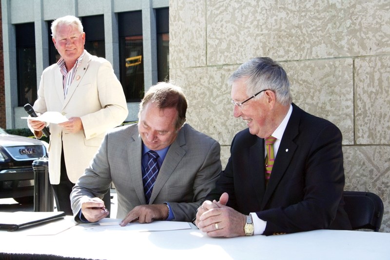 Jim Wood and Morris Flewwelling sign a proclamation making Sept. 11-17 Portraits of Honour Week.