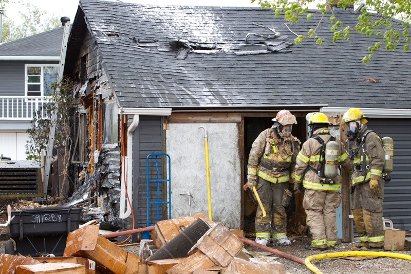 Firefighters exit an outbuilding on a property two miles north of Carstairs on Rge. Rd. 20 last Wednesday evening.