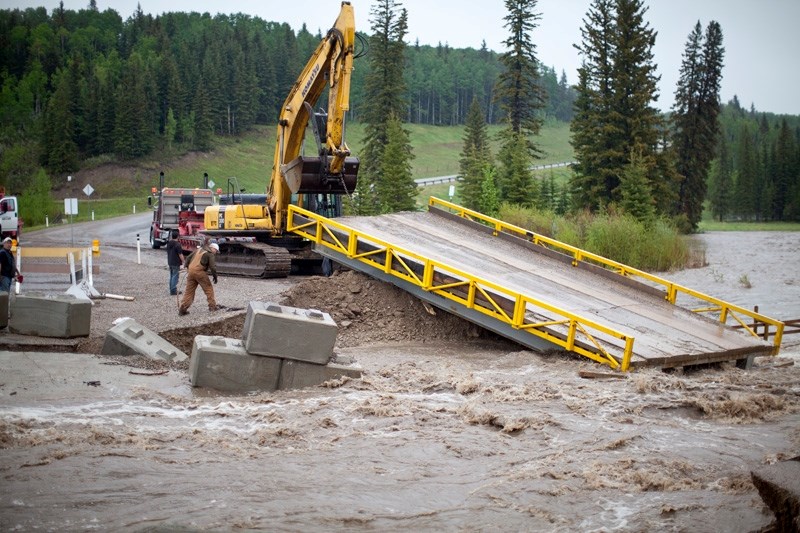 Workers from Rick Martin Trucking rushed to remove the temporary bridge across the Little Red Deer River last Wednesday afternoon after the foundation quickly began to erode