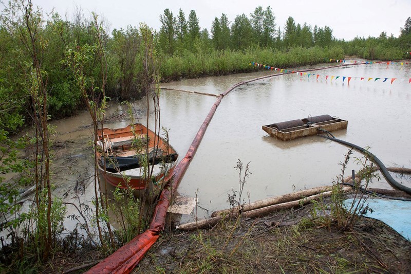 Booms are used along the river to direct oil to skimmers that are connected to powerful vacuum trucks.