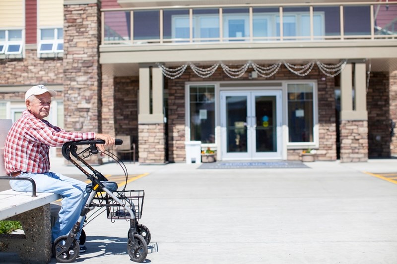 Resident Allan Anderson sits outside Mount View Lodge last Wednesday. The heat inside was stifling