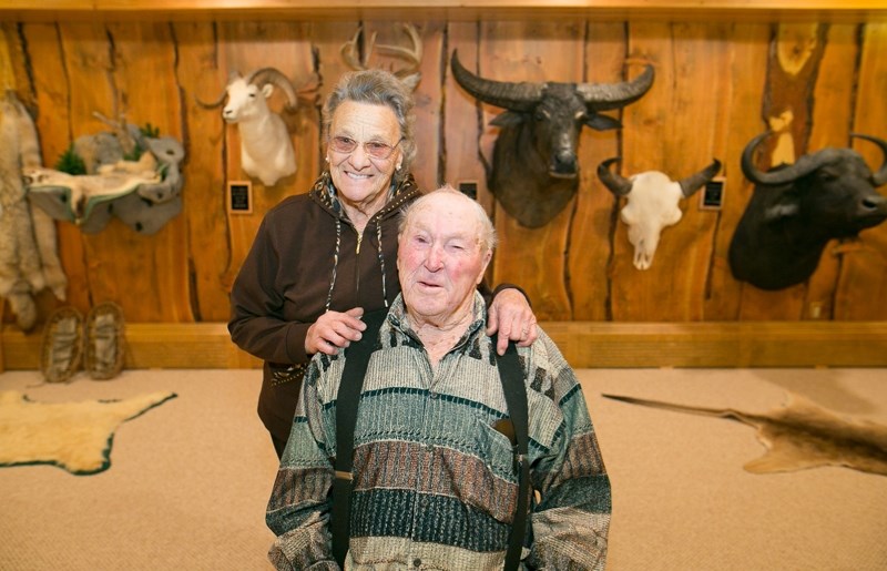 A LIFE OF ADVENTURE &#8211; Chester and Martha Mjolsness share a smile in front of some of Chester&#8217;s many wildlife trophies.