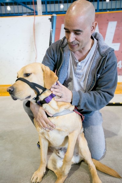 Scott Milton pets McCoy, his seizure response guide dog, at the Carstairs Animal Expo held at the Carstairs Memorial Arena last April. The 2017 Expo takes place April 8 in