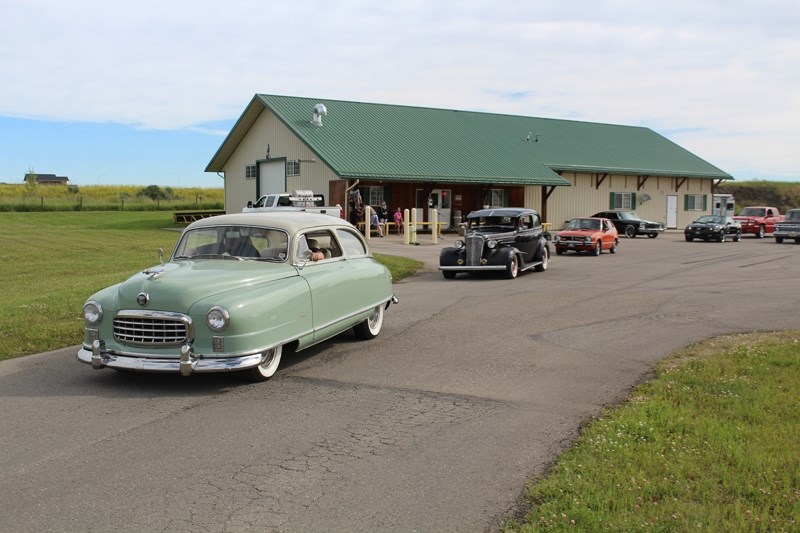 A fleet of cars pulls out of the Aardvark Car Wash in Carstairs during the third annual Suicide Awareness Cruze.