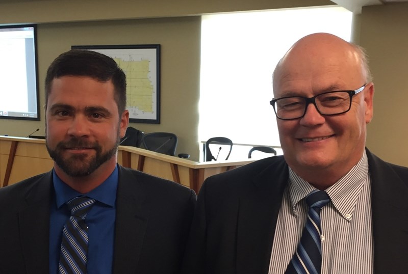 Jeff Holmes, left, and Tony Martens share a smile during the Sept. 27 council meeting.