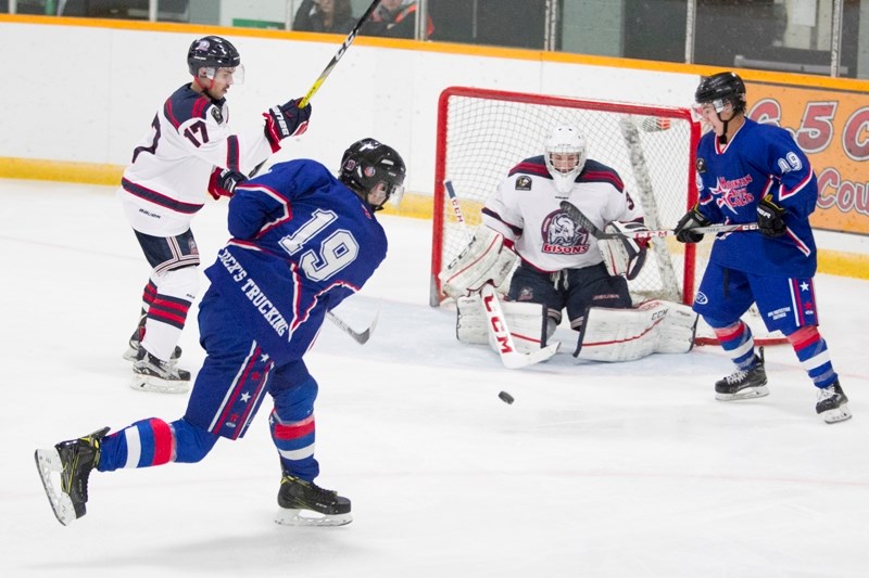 Mountainview Colts player Josh Gette, centre, takes a shot on the Okotoks Bisons goaltender during Friday&#8217;s home game.