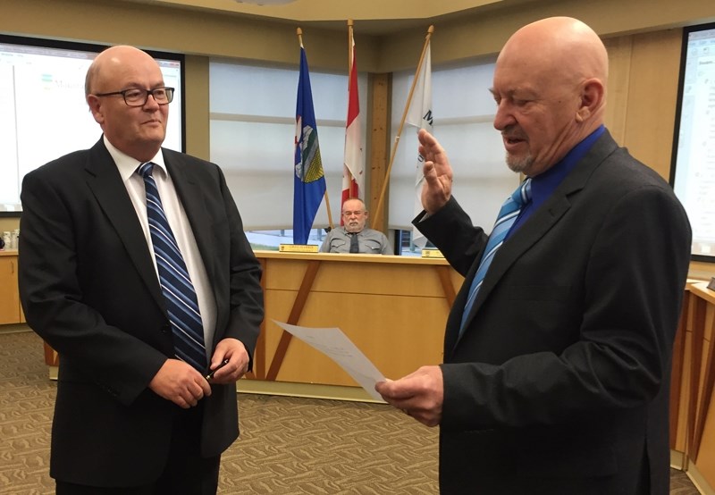 Bruce Beattie, right, is sworn in as Reeve by CAO Tony Martens, left, at the Oct. 25 organizational meeting. Councillor Greg Harris, centre, watches proceedings.