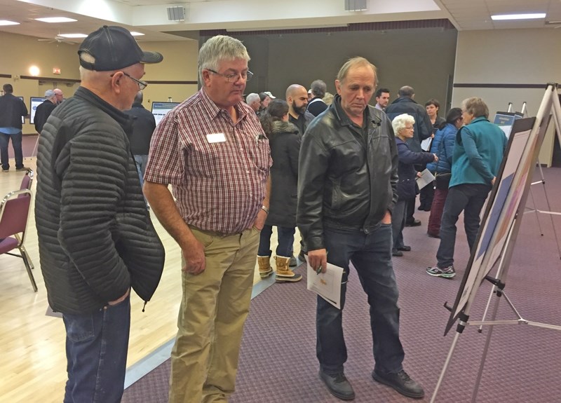 Mountain View County councillor Duncan Milne, centre, and guests look over displays at a Nov. 28 open house in Carstairs.