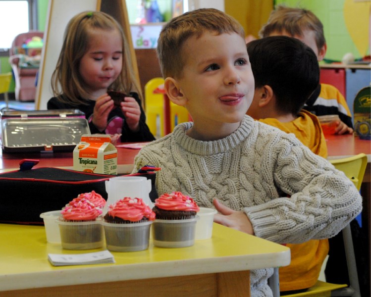 Young Kaleb enjoys a cupcake.