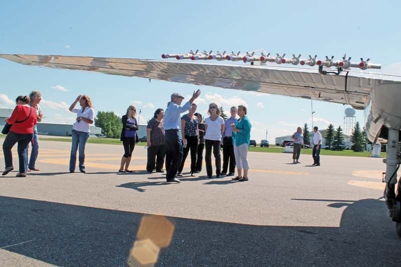 Guests look over a cloud seeding aircraft