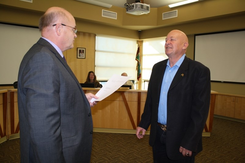 CAO Tony Martens swears in Bruce Beattie as reeve of Mountain View County.