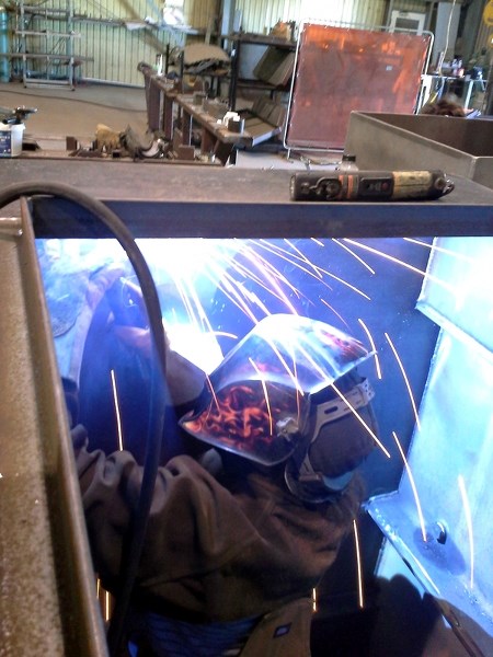 Midway area welder Carol Dallas at work. Darcy MacKinnon, project leader of the new manufacturing company that will soon occupy the old Midway School, says he may be hiring