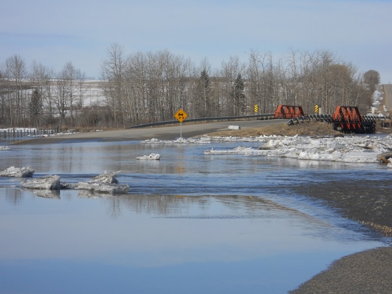 Flood water pour over the Bergen Road near Highway 766.