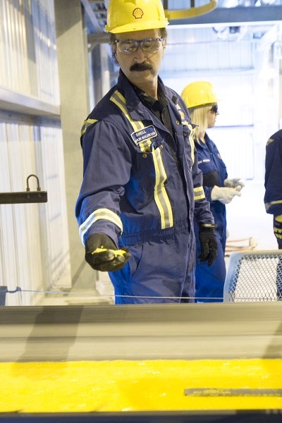 Superintendent Dave Kolesnik holds sulphur pastilles made in one of 46 rotoformer machines at the massive Shell Shantz plant west of Didsbury. The plant recently passed the