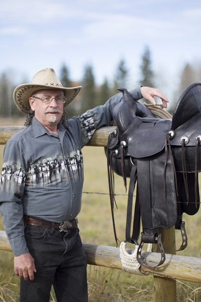 Greg Essery stands with one of his refurbished saddles.