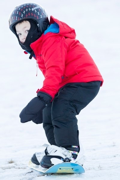 Burke Jones learns to snowboard at the Butte at the Didsbury Golf Course on Dec. 23. Burke is setting a great example by wearing his safety helmet on the hill.