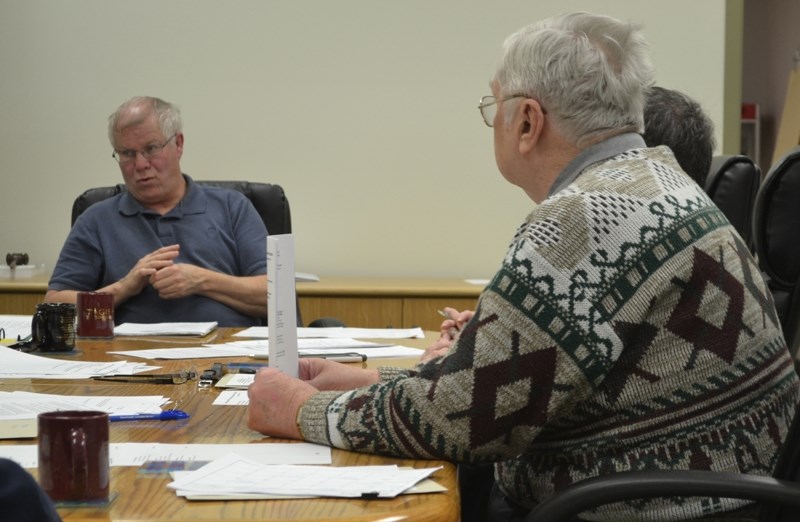 Bowden mayor Robb Stuart (left) discusses frustrations regarding Alberta Transportation with fellow councillors, including Earl Wilson (right, foreground).