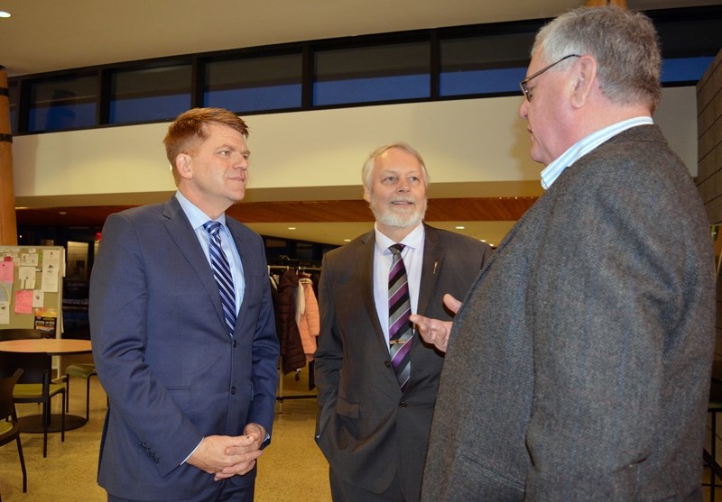 Wildrose Leader Brian Jean, left, and Sylvan Lake-Innisfail MLA Don McIntyre speak with a party member during a Wildrose fundraiser in Innisfail in Feb. 19.