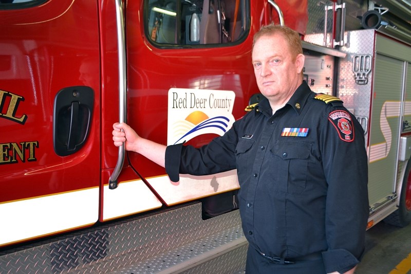 Dean Clark, Innisfail fire chief, with his department&#8217;s fire truck that serves Red Deer County. Last week, ongoing dry and hot weather conditions forced the county to