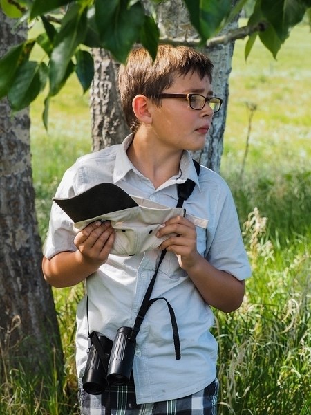 Nate Reist gently cradles a baby bluebird in his ball cap during the Legacy Land Trust Society&#8217;s second annual friendraiser on June 4, which included a nature walk on a 