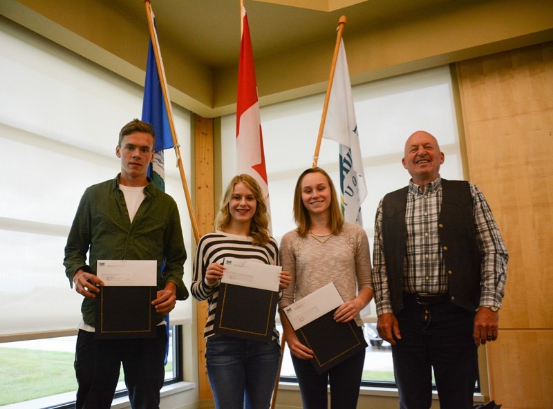 Students (left to right) Samuel Neufeld, Ciana Anhorn and Alexa Bricker receive their citizenship award certificates from Mountain View County reeve Bruce Beattie during a