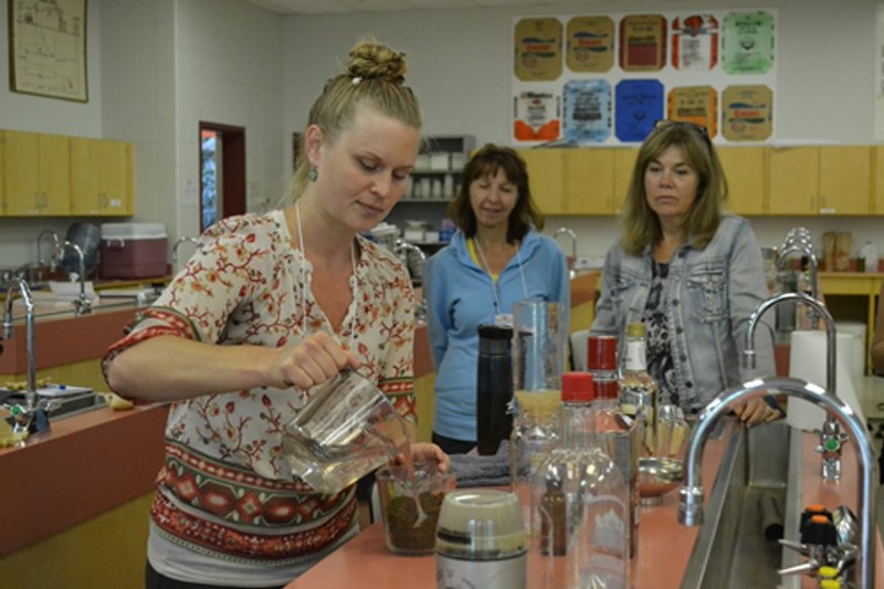 Instructor Jenni Cyman, left, mixes vodka and ground-up St. John&#8217;s Wort to create a medicine during the Introduction to Plant Medicine workshop during Hort Week 2016 at 