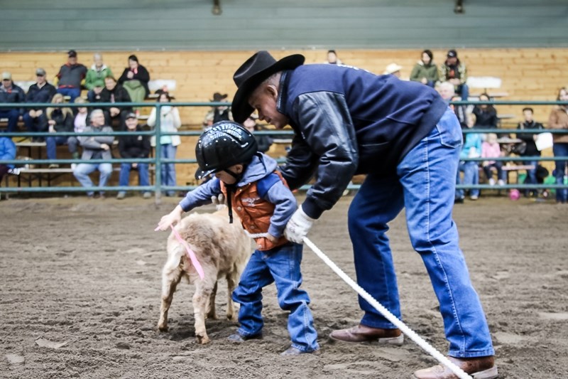 Racin Fike competes in the goat untying event with help from Gordie Aascow at the Oct. 29 rodeo event.