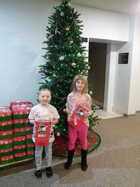 Georgia (left) and August McComb were two of kids who came out to help pack shoeboxes.