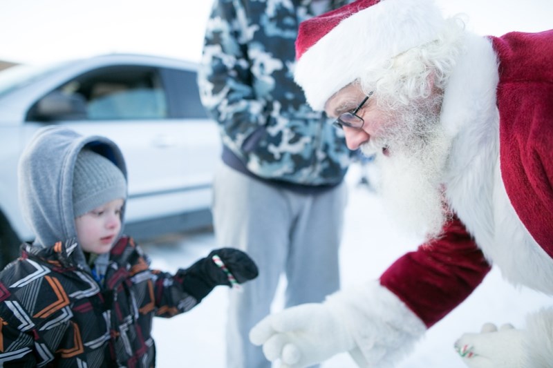 Santa Claus gives a candy cane to a child during the train stopover in Didsbury.