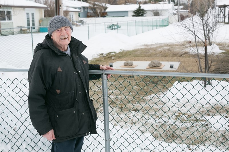 Allan Little at the fenceline between his residence and the Didsbury Golf Course on Dec. 20. He is not happy with construction plans.