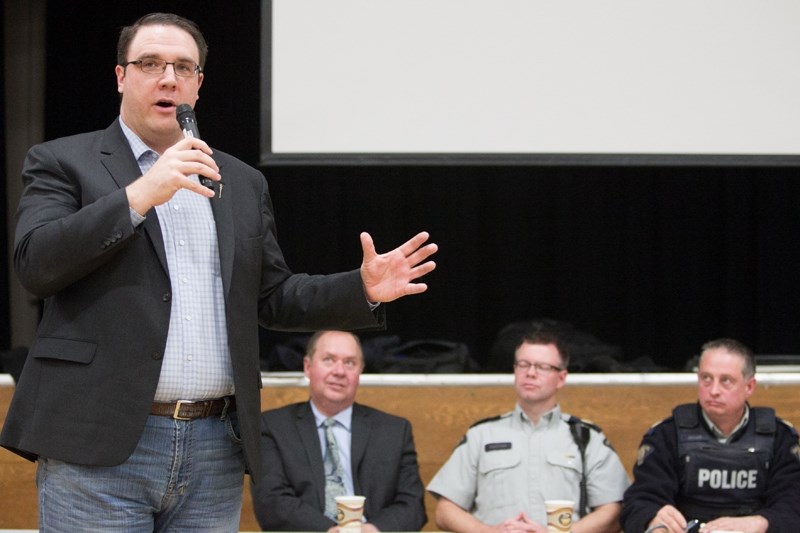 MLA Jason Nixon, left, speaks during the rural crime town hall at Eagle Hill Memorial Community Centre on Feb. 20. Seated behind him are, left to right, Red Deer County mayor 