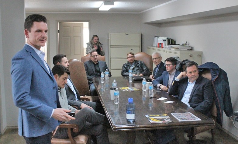 Andrew Arnill, left, operations manager for West-Can Seal Coating, gives a presentation about the company to Jason Kenney, near right, leader of the United Conservative