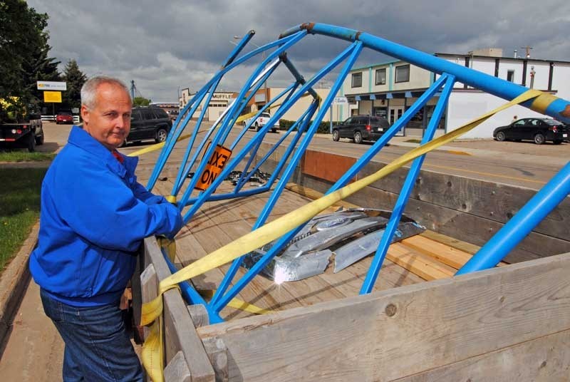 Innisfail resident Colin Loughlin stands by his front gate, which was flung 250 feet down his driveway on June 2, 2011. It is the second time Loughlin&#8217;s gate, located