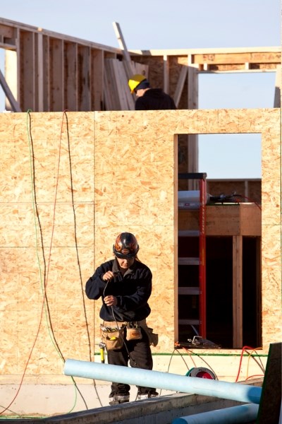 A construction crew works on a house in the Madison Park development off of 50 Street last Friday.