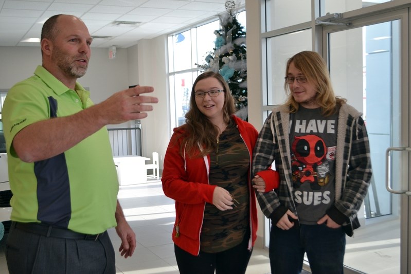 Jeff Denham, dealer principal of Fourlane Ford Sales, greets a shocked Taylor Gormley and Jared Teufel at the front door of the dealership and shows them their new car, a