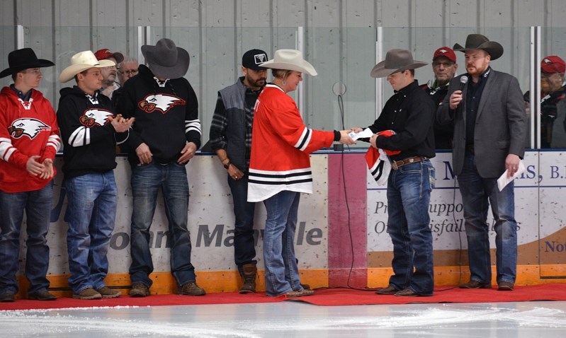 Innisfail Eagles president Dusty Daines receives a cheque for $5,000 from a representative of A Night at the Ranch fundraiser. Professional bull rider Ty Pozzobon helped