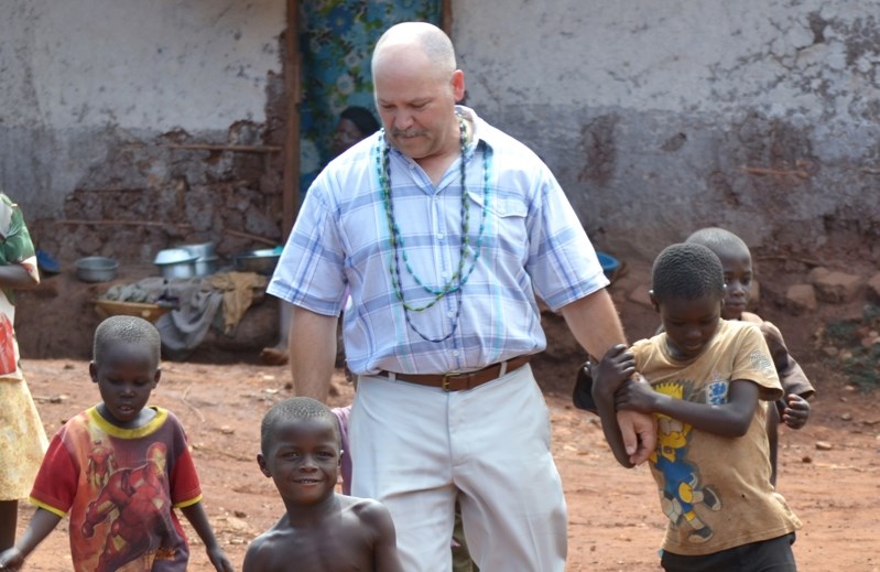 Ugandan children greet a volunteer with Charis Global Community Aid, a local non-profit outreach organization that helps improve lives of families in Uganda through various