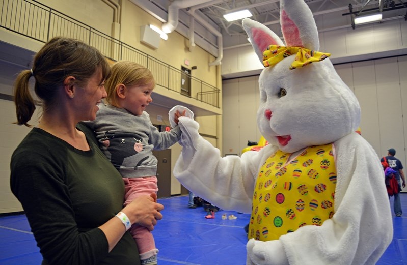 Maria Thomas smiles as she meets the Easter Bunny during the Easter celebration event in Penhold on Saturday.