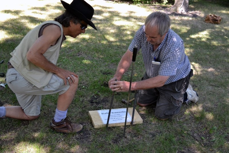 Innisfailian Johnnie Bachusky and cousin Brian Lesko install a temporary marker earlier this month at the gravesite of their uncle Walter Kravcenko at Winnipeg&#8217;s