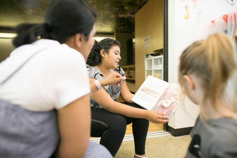 Volunteer Juliana Cotacio, a native of Colombia, reads a story to children in both Spanish and English.