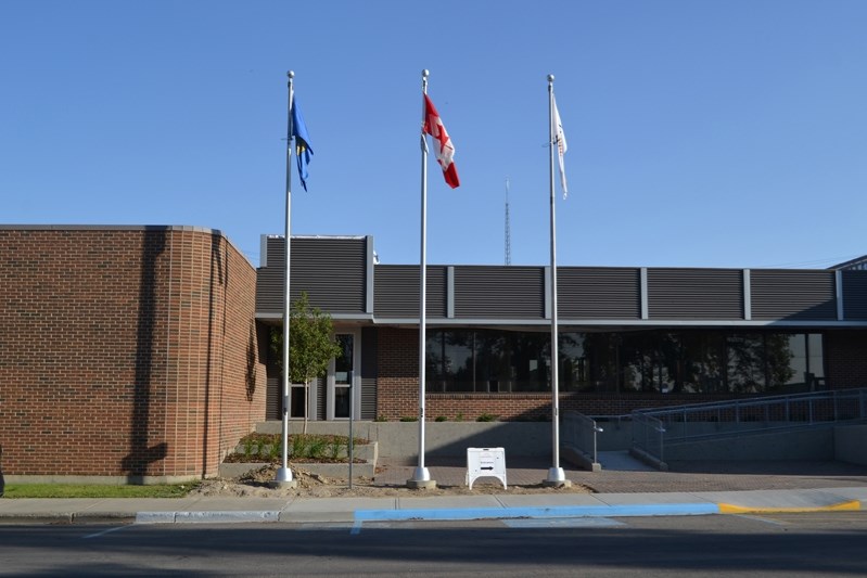 The three flagpoles in front of Innisfail&#8217;s town hall on Sept. 6. The federal Department of Heritage says they are in the right order, but Jim Behan, the